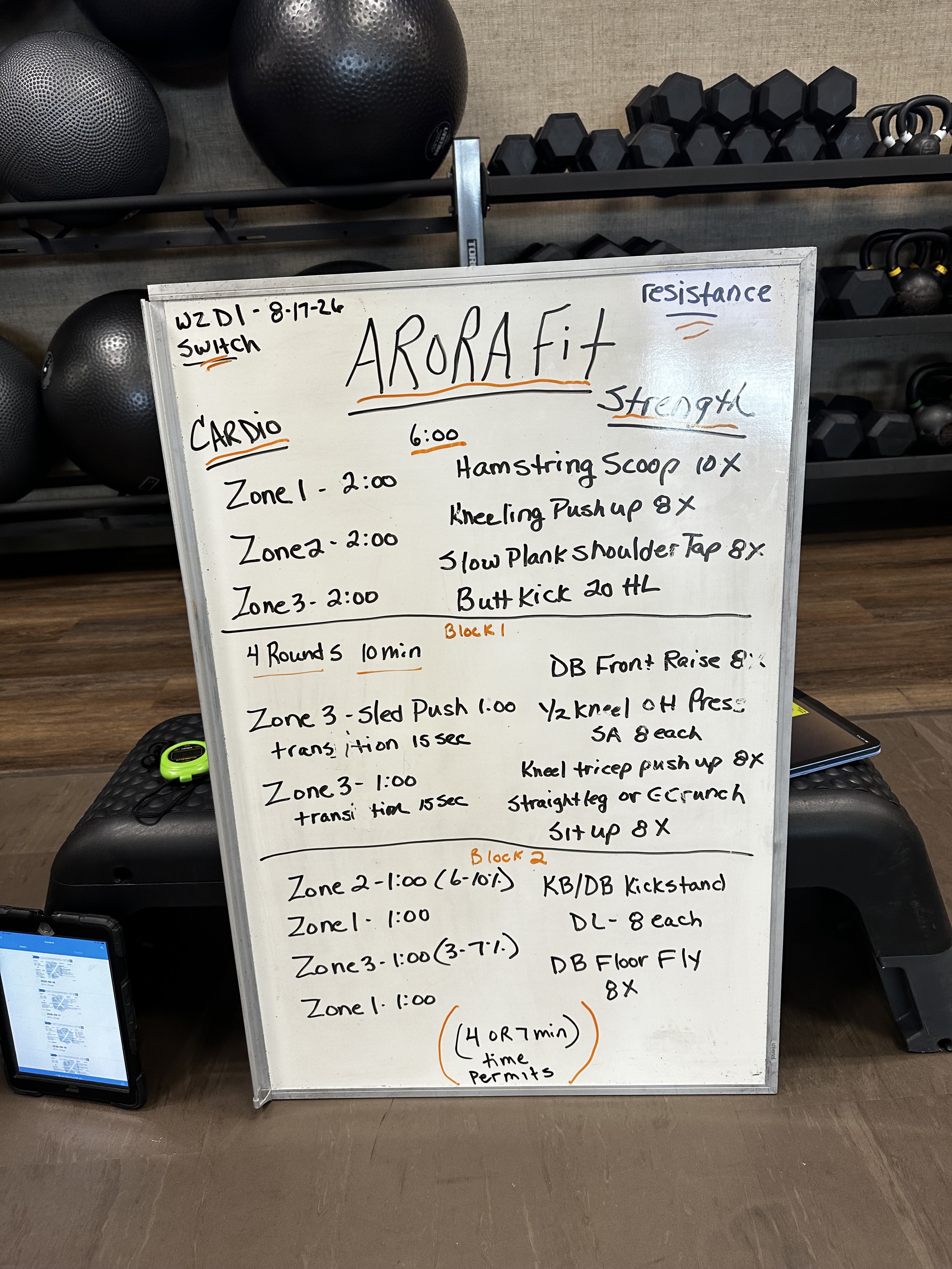ARORA Fit whiteboard dated August 17, 2026, showing cardio, sled, and strength exercises
